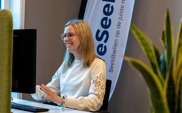 WeSeeDo'er Lynn zit achter haar bureau en geeft een kennissessie.