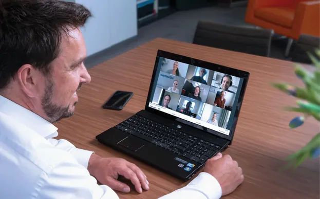 Man neemt deel aan een teamgesprek via WeSeeDo op zijn laptop.