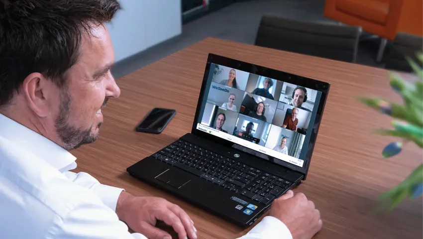 Man neemt deel aan een teamgesprek via WeSeeDo op zijn laptop.