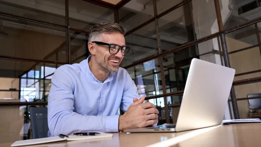 Meneer zit achter laptop te beeldbellen met WeSeeDo in de financiele sector