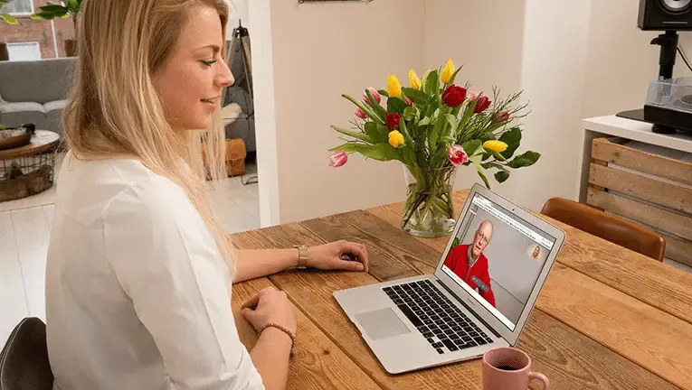 Vrouw beeldbelt met een oudere man via WeSeeDo, illustratie van de samenwerking met PharmaPartners voor veilig beeldbellen in de zorg.