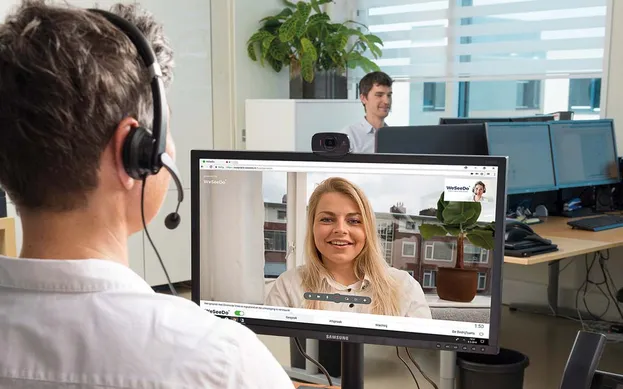 Twee mensen voeren op kantoor een videogesprek via WeSeeDo.