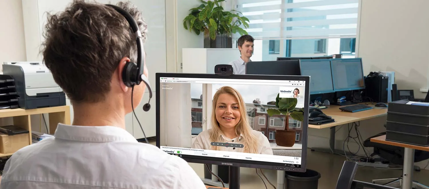 Twee mensen voeren op kantoor een videogesprek via WeSeeDo.