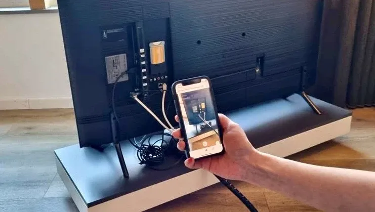 Iemand met een telefoon laat via WeSeeDo een probleem zien.