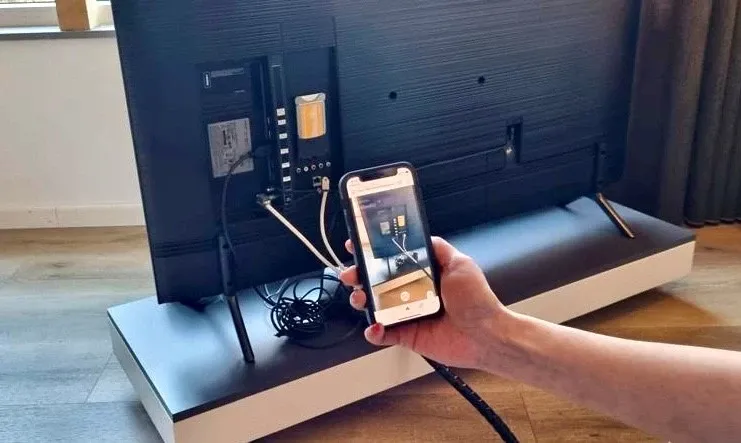 Iemand met een telefoon laat via WeSeeDo een probleem zien.